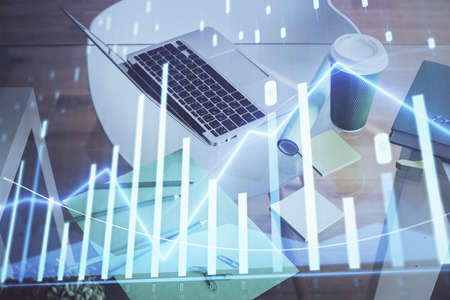 Stock market graph and table with computer background. Multi exposure. Concept of financial...