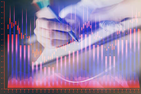 Financial forex graph displayed on hands taking notes background. Concept of research. Double...