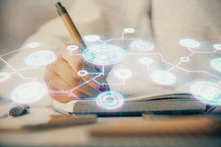 Social network theme hologram over hands taking notes background. Concept of global international people connect. Double exposureの写真素材