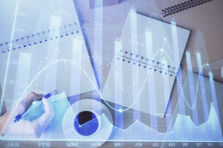 Multi exposure of woman's hands making notes with forex graph hologram. Concept of technical analysis.の写真素材