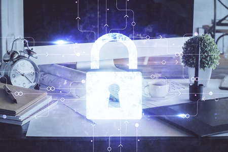 Double exposure of desktop with computer and lock icon hologram. Concept of data safety.
