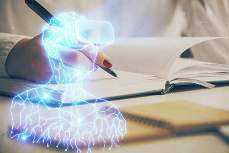 AR hologram over hands taking notes background. Concept of augmented reality. Double exposureの写真素材