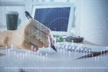 Financial forex graph drawn over hands taking notes background. Concept of research. Multi exposureの写真素材