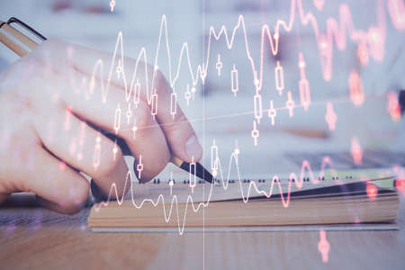 Double exposure of man doing notes of stock market with forex graph. Concept of research and...