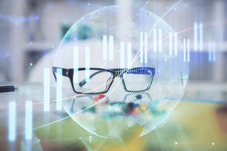Financial graph hologram with glasses on the table background. Concept of business. Double exposure.