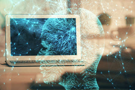 Double exposure of work space with computer and human brain drawing hologram. Brainstorm concept.