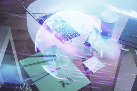 Computer on desktop in office with technology theme hologram. Double exposure. Tech concept.の写真素材