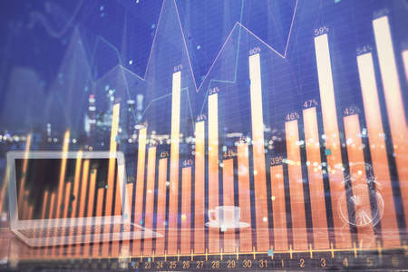Forex market graph hologram and personal computer on background. Multi exposure. Concept of investment.の写真素材