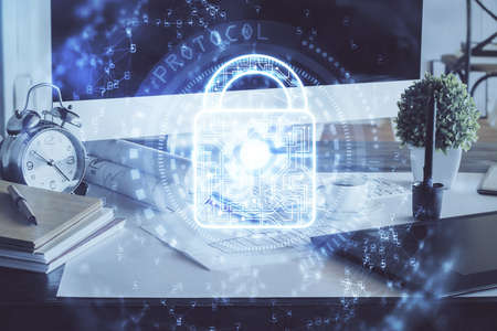 Double exposure of desktop with computer and lock icon hologram. Concept of data safety.