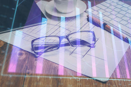 Financial chart hologram with glasses on the table background. Concept of business. Double exposure.の写真素材
