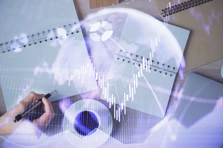 Multi exposure of woman's hands making notes with forex graph hologram. Concept of technical...