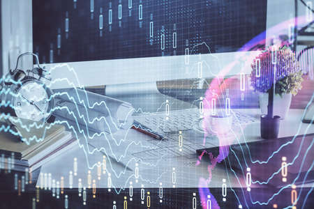 Stock market graph and table with computer background. Multi exposure. Concept of financial...