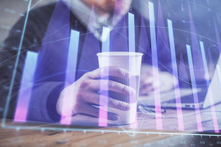 Forex graph with businessman working on computer in office on background. Concept of hardworking....
