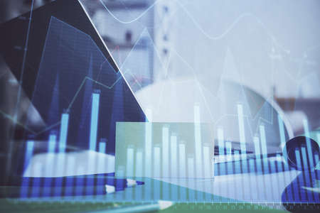 Stock market graph and table with computer background. Multi exposure. Concept of financial...
