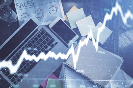Financial market graph and top view computer on the desktop background. Multi exposure. Investment...