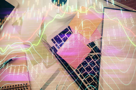 Multi exposure of financial chart drawing over table background with computer. Concept of research and analysis. Top view.の写真素材