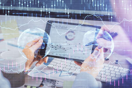 Double exposure of man's hands holding and using a phone and financial chart drawing. Market...