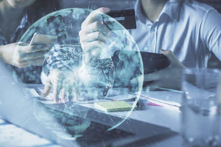 Double exposure of man and woman on-line shopping holding a credit card and business theme hologram...