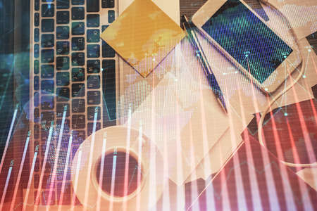 Double exposure of financial chart drawing over table background with computer. Concept of research...