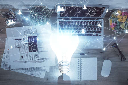 Bulb drawing over computer on the desktop background. Top view. Double exposure. Idea concept.