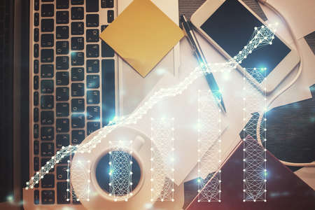 Double exposure of financial chart drawing over table background with computer. Concept of research...
