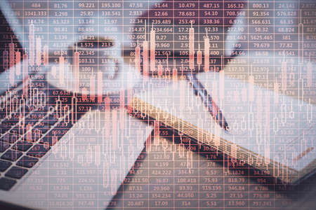 Double exposure of forex chart drawing and desktop with coffee and items on table background. Concept of financial market tradingの写真素材