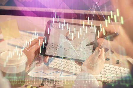 Double exposure of man's hands holding and using a phone and financial chart drawing. Market...