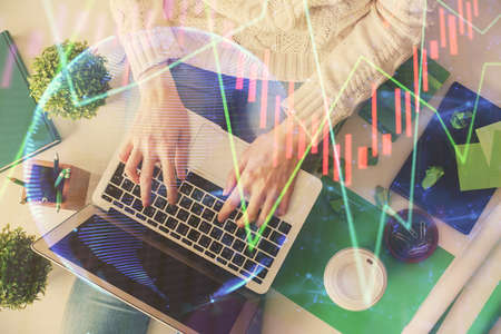 Double exposure of woman hands working on computer and forex chart hologram drawing. Top View....