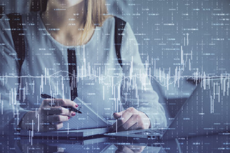 Double exposure of businesswoman hands typing on computer and financial graph hologram drawing. Stock market analysis concept.の写真素材