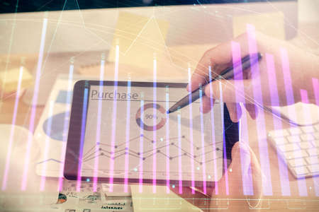 Double exposure of man's hands holding and using a phone and financial chart drawing. Market analysis concept.の写真素材