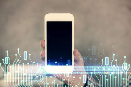 Double exposure of man's hand holding and using a digital device and data theme hologram drawing. Technology concept.の写真素材