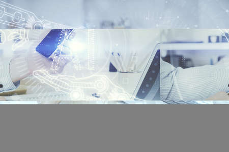 Double exposure of man's hand holding and using a digital device and data theme hologram drawing....