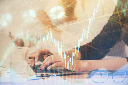 Multi exposure of woman hands typing on computer and financial graph hologram drawing. Stock market...