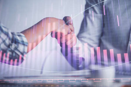 Double exposure of forex graph hologram and handshake of two men. Stock market concept.