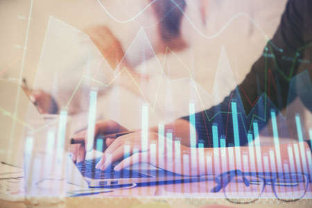 Multi exposure of woman hands typing on computer and financial graph hologram drawing. Stock market...