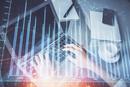 Double exposure of woman hands typing on computer and forex chart hologram drawing. Stock market...