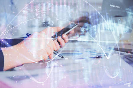 Double exposure of man's hands holding and using a phone and international business theme drawing.