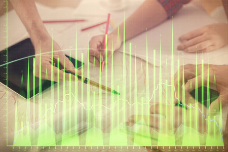 Double exposure of forex graph drawing and man and woman working together holding and using a mobile device. Trade concept.の写真素材