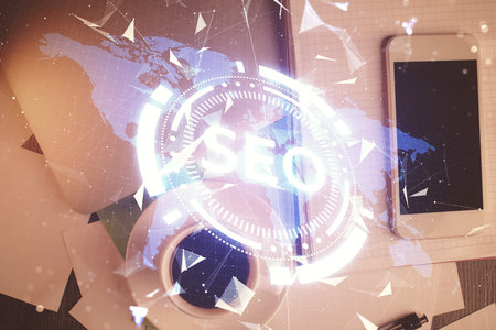 Double exposure of SEO hologram drawing over desktop. Top view. Search optimization concept.の写真素材