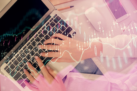 Double exposure of woman hands working on computer and forex chart hologram drawing. Top View....