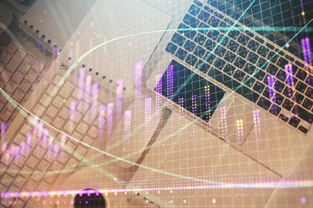 Financial market graph and top view computer on the desktop background. Multi exposure. Investment...