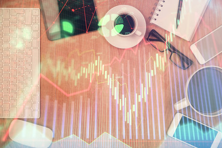 Double exposure of financial chart hologram over desktop with phone. Top view. Mobile trade platform concept.の写真素材