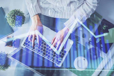 Double exposure of woman hands working on computer and forex chart hologram drawing. Top View. Financial analysis concept.の写真素材