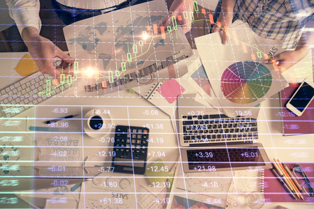 Double exposure of man and woman working together and financial chart hologram drawing. market analysis concept. Computer background. Top View.の写真素材