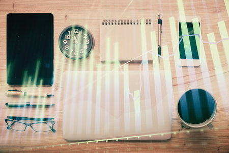 Double exposure of forex graph hologram over desktop with phone. Top view. Mobile trade platform concept.の写真素材