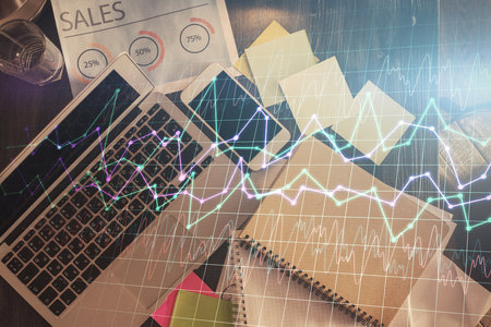 Financial market graph and top view computer on the desktop background. Multi exposure. Investment concept.の写真素材