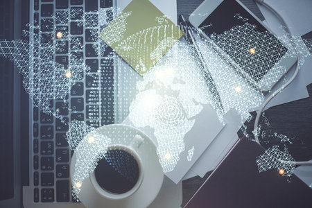Business theme hologram drawings over computer on the desktop background. Top view. Multi exposure. Concept of international connections.の写真素材