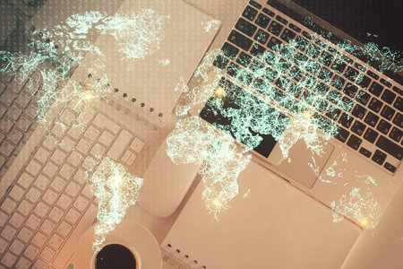 Social network hologram drawings over computer on the desktop background. Top view. Double exposure.の写真素材