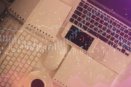 Financial market graph and top view computer on the desktop background. Multi exposure. Investment...