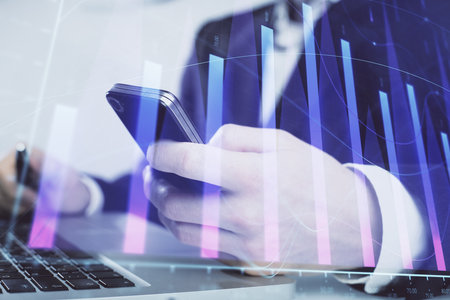 Multi exposure of man's hands holding and using a digital phone and forex graph drawing. Financial market concept.の写真素材